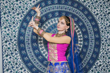 Portrait of a female model in ethnic indian costume with  jewellery and traditional makeup.