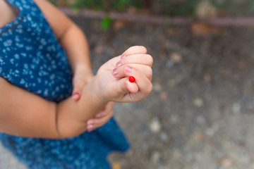 girl's hand. red berries lie on a children's palm