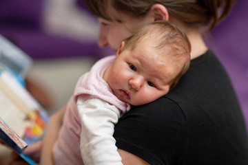 the baby sleeps on the shoulder of the mother woman