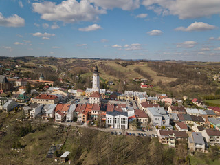 Fototapeta na wymiar Biecz, Poland - 3 9 2019: Panorama of the historic center of the European medieval city on the picturesque green hills. Trips to architectural monuments: temples, central square, town hall, municipal