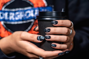 black matte manicure has different lettering with dark background " help"