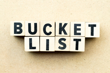 Letter block in word bucket list on wood background
