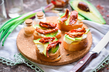 Baguette tarts with avocado and dried tomatoes.