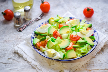 Salad of avocado, fresh cucumbers, cherry tomatoes, quail eggs and lettuce.