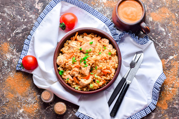 Bulgur plov with chicken, fresh cherry tomatoes and tomato sauce.