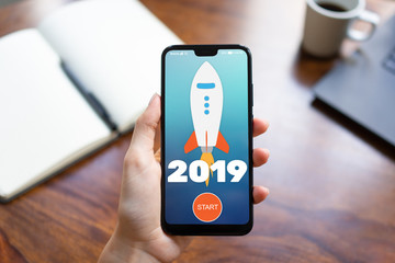 2019 year Rocket start button on mobile phone screen. Business concept.