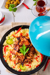 Tajin with couscous, vegetables and meat on white background