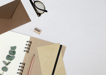 Notebook, pencil, sharpener, spectacles, envelopes, eucalyptus branch on the white background