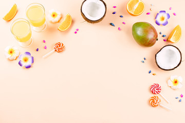 Colorful summer concept flat lay with fresh juice, tropical fruits, lollipops and multicolor seashells, copyspace