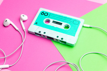 Retro old school 80-s or 90-s concept. Audio cassette on a bright blue-pink background