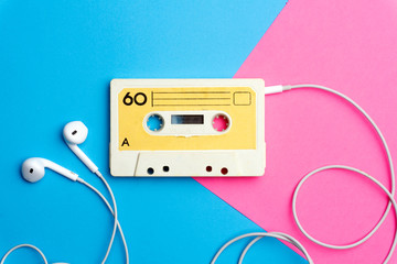 Retro old school 80-s or 90-s concept. Audio cassette on a bright blue-pink background