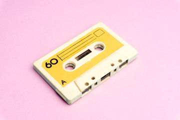 Retro old school 80-s or 90-s concept. Audio cassette on a bright blue-pink background