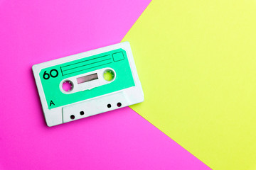 Retro old school 80-s or 90-s concept. Audio cassette on a bright blue-pink background