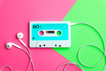 Retro old school 80-s or 90-s concept. Audio cassette on a bright blue-pink background