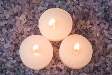 preparations for the bath and aromatherapy : three decorative candle stand in aromatic sea salt with lavender smell, view from above
