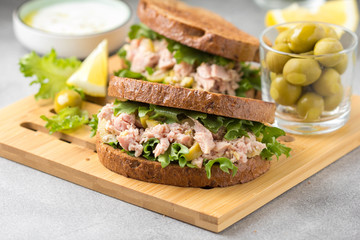 Sandwich with tuna, olives and lemon. Delicious lunch, healthy food, snack with fish on crispy toast