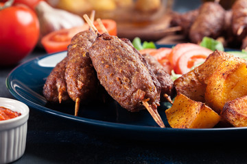 Grilled shish kebab served with fried potatoes