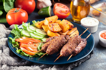 Grilled shish kebab served with fried potatoes