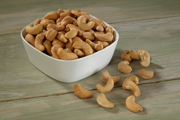 Cashew in white bowl on wooden background