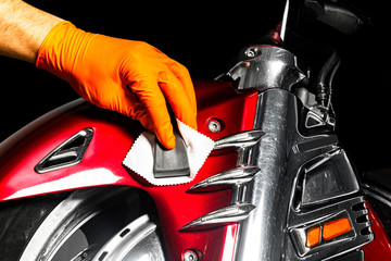 Car polish wax worker hands applying protective tape before polishing. Buffing and polishing...