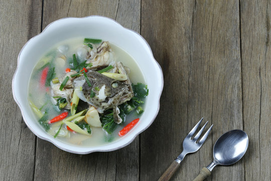 Tom Yum Grouper Fish Spicy Soup Of Thai Food In A Bowl On Wooden Floor.