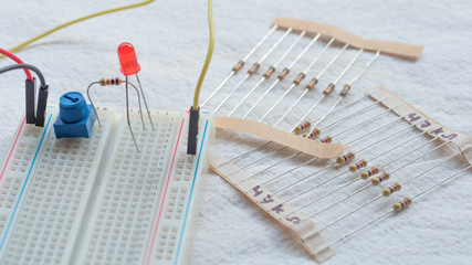 Potentiometer, resistors and red LED set up on a breadboard 