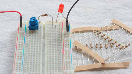 Potentiometer, resistors and red LED set up on a breadboard 