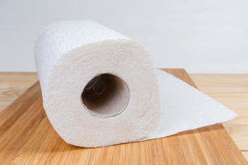 Roll of paper towels on wooden surface close-up
