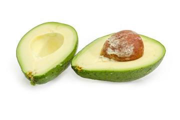 Green avocado fruit cut in half on a white background