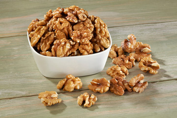 Walnut in white bowl on wooden background