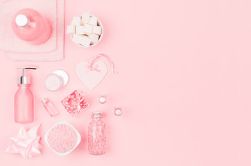 Cosmetics for salon aromatherapy, massage or bathroom - bath salt, cream, essential oil, towel, soap, bowls, bottles, heart, jewelry on elegance pink background.