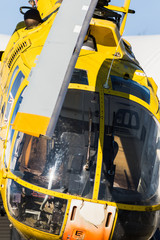 detail of the rotor of a yellow helicopter with the sky in the background