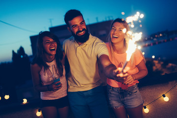 Group of happy friends celebrating at rooftop