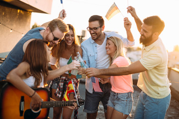 Group of happy friends having party on rooftop