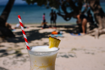Fresh alcohol cocktail on the beach. Cold pina colada on seascape background. Cool pineapple cocktail with straw. Paradise background. Exotic resort. Tropical vacation and travel. Luxury relax.