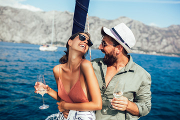 Loving couple spending happy time on a yacht at sea. Luxury vacation on a seaboat.
