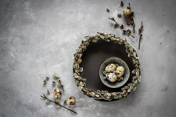 Quail eggs and pussy willow wreath as a symbols of spring and Easter  with a copy space, dark mood