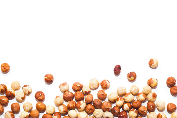White background with unpeeled hazelnuts