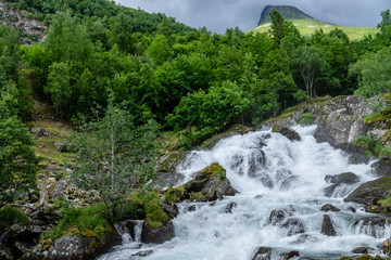 Naklejka na ściany i meble Beautiful waterfall down a mountainside in Norway