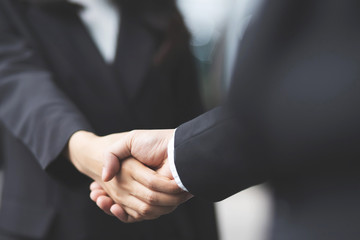 Closeup of a businessman hand shake businesswoman between two colleagues  OK, succeed in business...