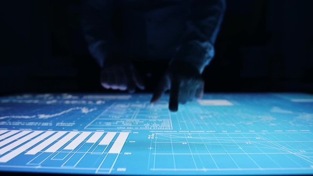 Man works charts, diagram indicators touch screen sensory interactive table 