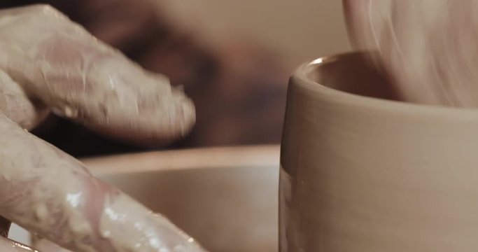 Hands of the master potter making ceramic products on the potter's wheel close-up. Handmade, craft