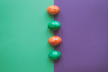 Easter eggs on green and violet background.