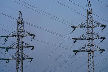 Voltage towers with sky background at the sunset. Image of overhead power lines.