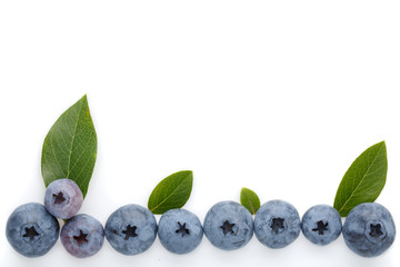 Fresh ripe blueberry berries and leaves isolated on white background. Top view.
