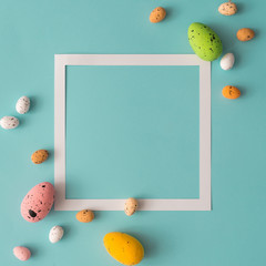 Easter composition made with colorful eggs on bright blue background. Creative minimal holiday concept.