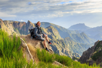 Young handsome tourist in the mountains of Madeira at Pico do Areeiro (Arieiro), while hiking to Pico Ruivo on a cloudy summer day - obrazy, fototapety, plakaty