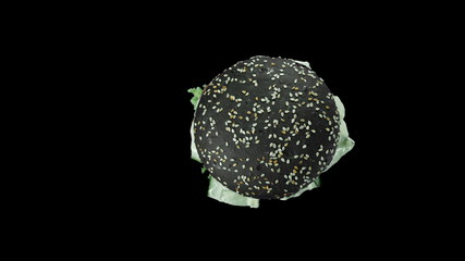 Large burger with black bun and lettuce sticking out from under the bun, top view of a burger, isolated black background