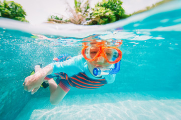 little boy swim underwater with mask in tropical resort