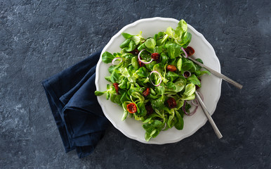 Bowl salad green mache leaves baked tomatoes top view